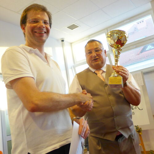 Tournament winner Adam Czuchnicki receives the trophy from Krzysztof Wolski