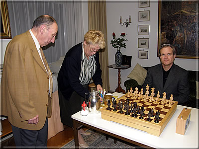 John Donaldson vor dem Beginn der Partie, die Augen wohl zur Göttin Caissa gerichtet. Frau Klittich-Pfankuch kümmert sich einmal mehr vorbildlich um das leibliche Wohl ihrer Gäste.